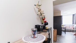 A modern kitchen with a wooden countertop, a coffee maker, and a vase with flowers. - City Center Studio Apartments 1 (Plovdiv)