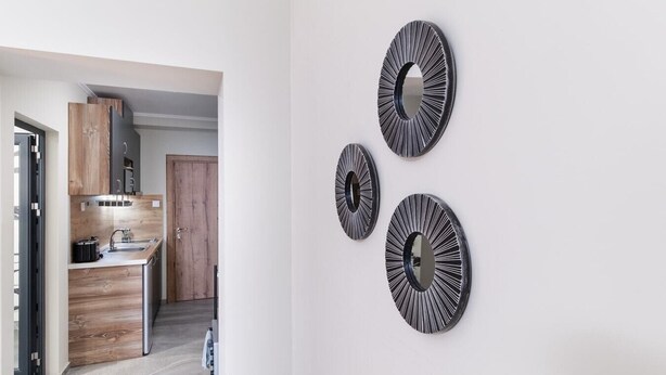 A modern kitchen with wooden cabinets and a built-in oven. - City Center Studio Apartments 1 (Plovdiv)