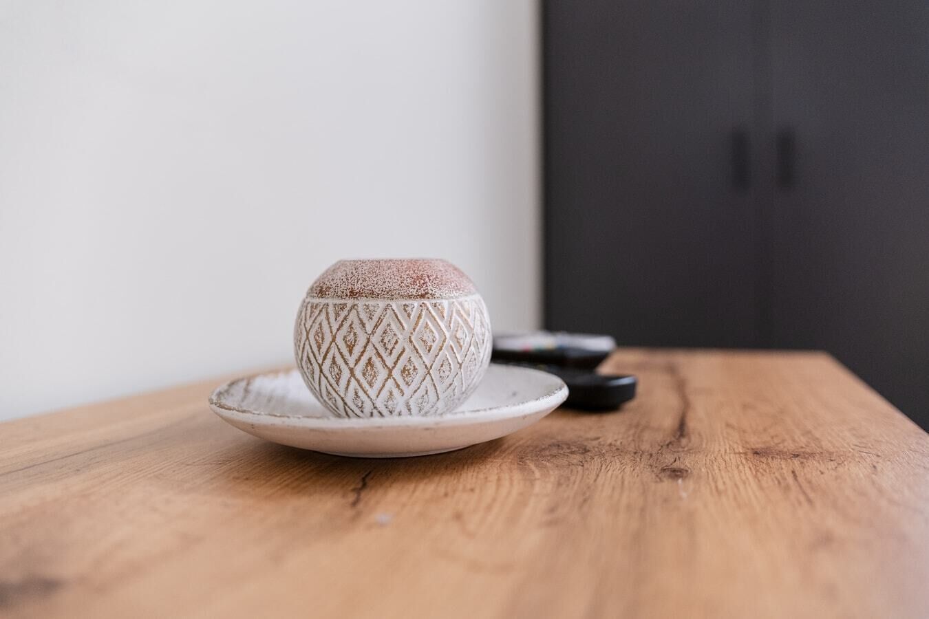 A ceramic mug with a geometric pattern on a wooden table.