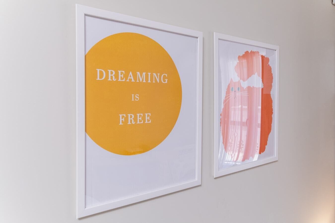 Deux œuvres d’art encadrées sont accrochées au mur.