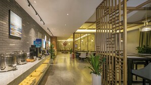 A hotel lobby with a buffet area, seating, and a decorative wooden partition. - Mehood Lestie International Hotel Chongqing Yuzhong Lianglukou Metro Branch (Chongqing)