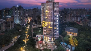A high-rise hotel with multiple floors, surrounded by other buildings and a parking area. - Mehood Lestie International Hotel Chongqing Yuzhong Lianglukou Metro Branch (Chongqing)