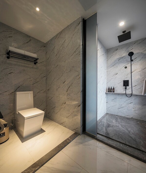 A modern bathroom with a toilet, a shower area, and marble walls. - Mehood Lestie International Hotel Chongqing Yuzhong Lianglukou Metro Branch (Chongqing)
