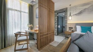 A modern hotel room with a desk, a bed, and a view of the mountains. - Mehood Lestie International Hotel Chongqing Yuzhong Lianglukou Metro Branch (Chongqing)