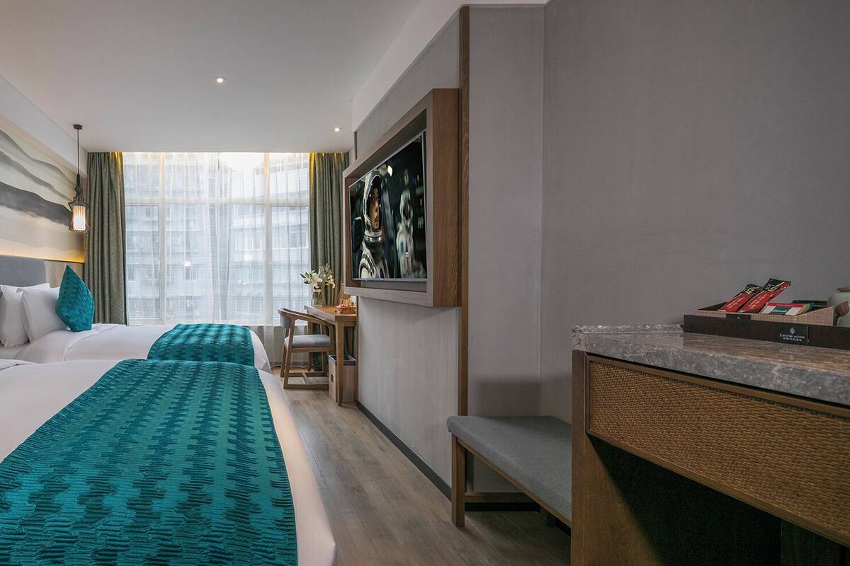 A hotel room with a large bed, a desk, and a TV.