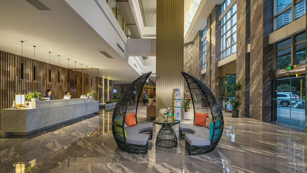 A spacious lobby with a reception desk, seating area with chairs, and a large column. - Mehood Lestie International Hotel Chongqing Yuzhong Lianglukou Metro Branch (Chongqing)