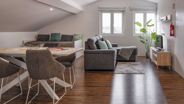 Un salon moderne comprenant un coin repas, un canapé, une table basse et un meuble pour la télévision.