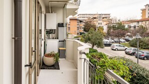 A balcony with a view of parked cars and buildings. - GuestHost - Rimini Oasis of Peace & Relaxation! (Rimini)