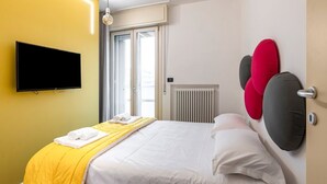 A hotel room with a bed, a television, a window, and a radiator. - GuestHost - Rimini Oasis of Peace & Relaxation! (Rimini)