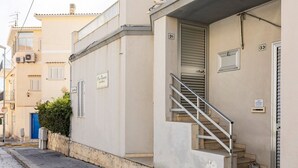 Un edificio con una escalera que lleva a una entrada, una puerta azul y un letrero que dice 'Cafeteria'.