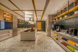 Una cocina moderna con una isla central, estanterías empotradas y un suelo estampado.