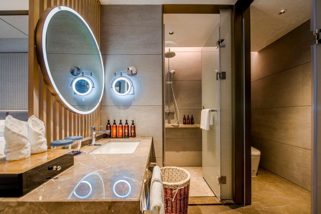 Ein modernes Badezimmer mit großem Spiegel, Waschbecken und Dusche.