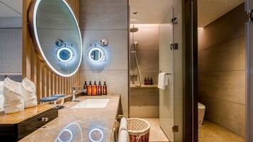 Ein modernes Badezimmer mit großem Spiegel, Waschbecken und Dusche.