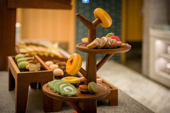 Una exhibición de diversos pasteles y postres sobre un soporte de madera.
