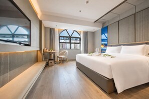 A modern hotel room with a large bed, a desk, and a view through a window. - LIZ International Hotel Panyu Ginza Shiqiao Metro Branch - Free Shuttle Bus to Canton Fair Complex During Canton Fair Period (Guangzhou)