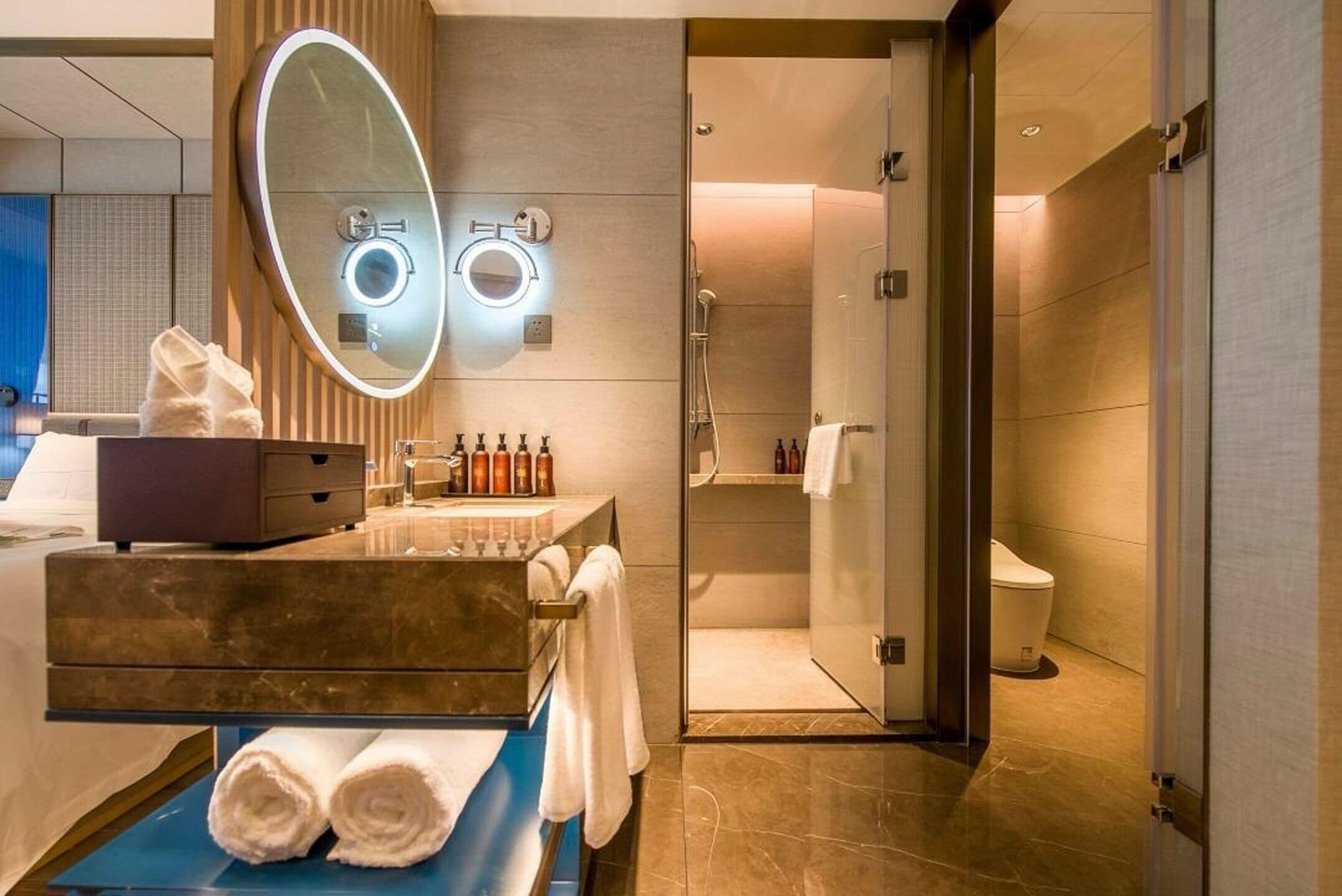 A modern bathroom with a vanity, mirror, and shower.