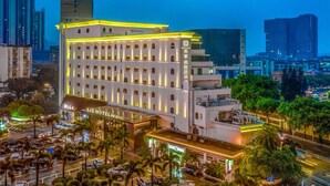 A multi-story hotel with a modern facade, illuminated windows, and a prominent entrance.