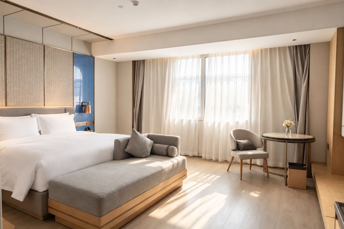 Et moderne hotelværelse med en stor seng, en sofa, et lille bord og en stol.
