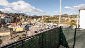 Une vue d’une ville côtière avec des bâtiments, un parking et un ciel dégagé.