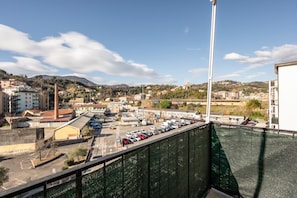 Vista de un pueblo costero con edificios, un estacionamiento y cielo despejado.