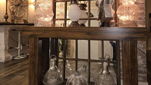 Une pièce avec un mur en briques, un grand miroir en arc de cercle et de magnifiques lustres en cristal décoratifs.