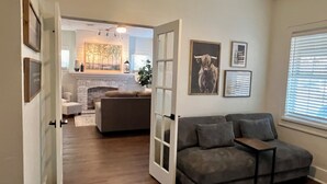 A living room with a grey sofa, a fireplace, and a dining area in the background.