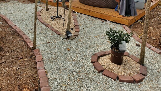 Una cabaña de madera con un espacio de estar techado al aire libre y un colchón en la terraza.