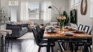 Een eetruimte met een houten tafel, zwarte stoelen en een bloevas.