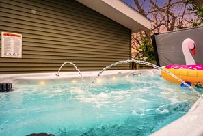 Un bain à remous avec une chaîne et un flotteur en forme de cygne.
