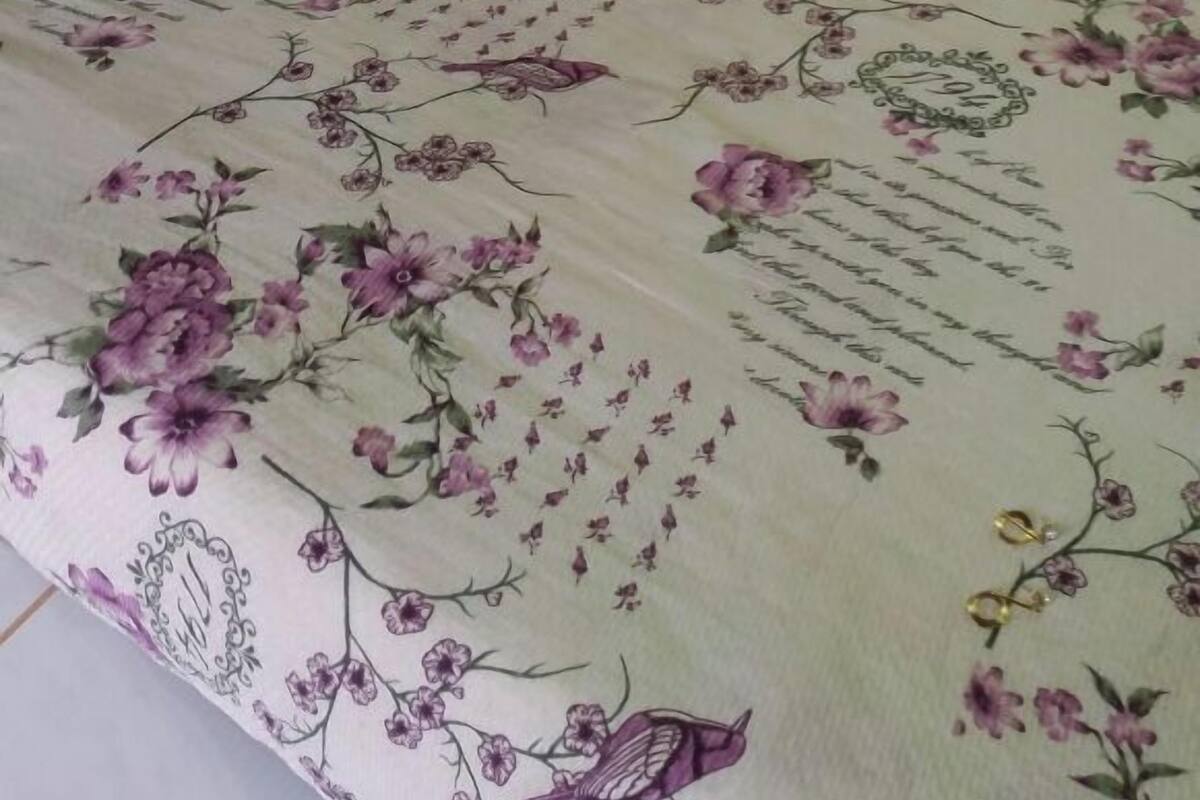 Ein Bett mit einem blumigen Bettüberwurf und einem Holzkopfende.