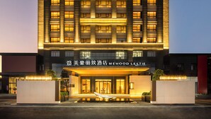 A multi-story hotel with illuminated signage and a modern facade. - Mehood Lestie International Hotel Panyu Flagship Branch - Free Shuttle Bus to Canton Fair Complex During Canton Fair Period (Guangzhou)