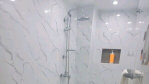 A bathroom with a toilet, shower, and towel rack. - Obynb premium  (Santo Domingo)