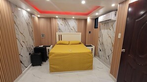 A hotel room with a bed, a wardrobe, a suitcase, and an air conditioning unit. - Obynb premium  (Santo Domingo)