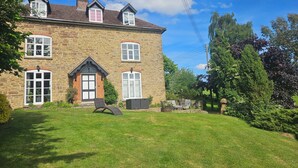 A stone building with a large lawn, a door, and windows. - Dog friendly 7 bed farmhouse near Malvern Hills with huge hot tub and games room (Cradley)