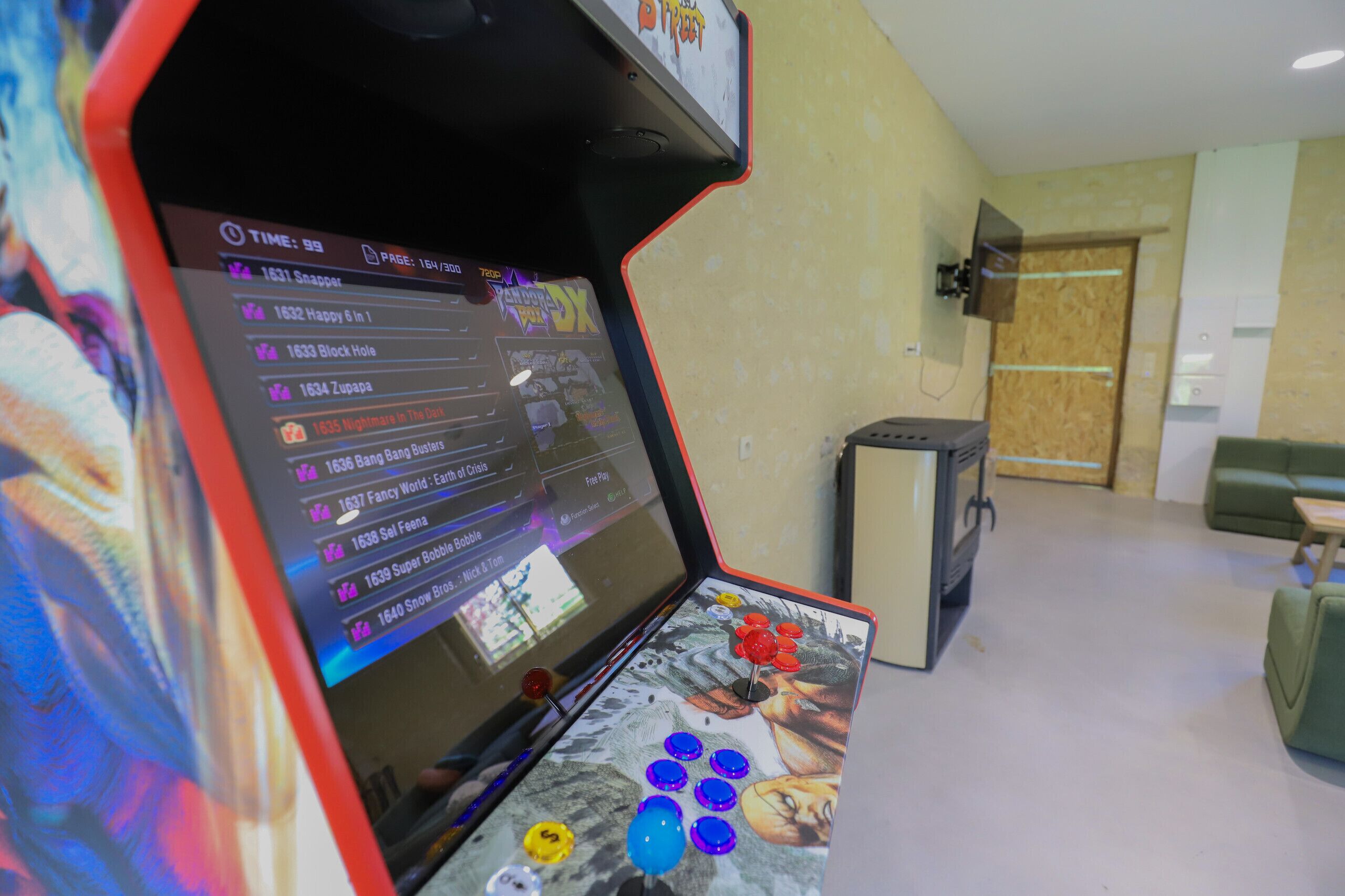 A gaming arcade with a screen displaying game titles and a joystick in the foreground.
