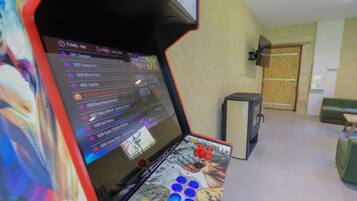 A gaming arcade with a screen displaying game titles and a joystick in the foreground.