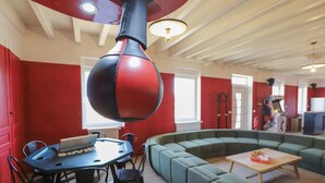 Un intérieur moderne avec une table ronde, des canapés verts et un objet sphérique rouge et noir.