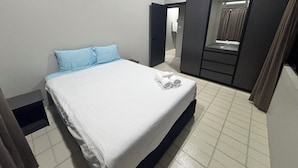 A hotel room with a bed, a wardrobe, a mirror, and a bathroom visible through an open door. - Dovu Residences (Labasa)