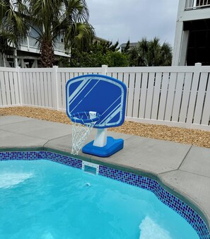 Une piscine avec un panier de basketball bleu et blanc.