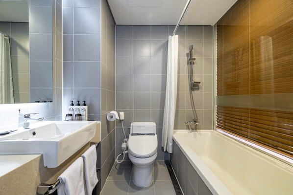 A modern bathroom with a white toilet, a sink, and a bathtub. - THE SKY HOTEL (Cheonan)