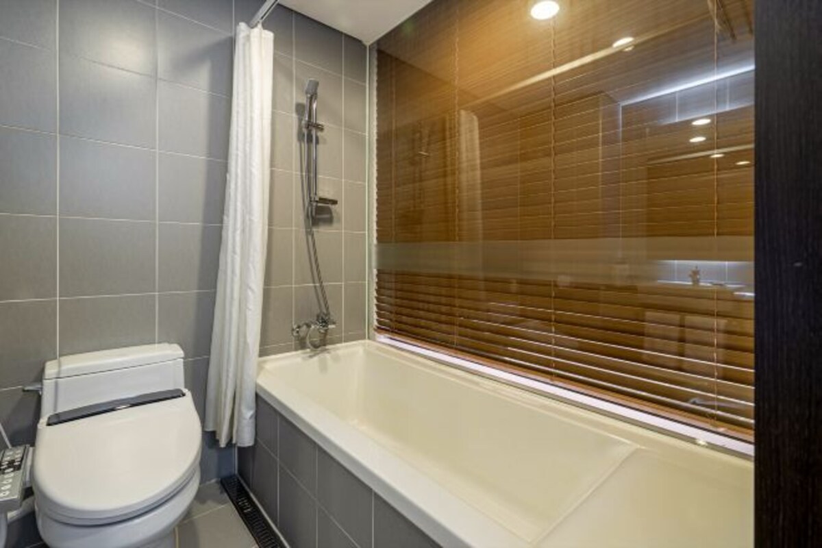 Ein modernes Badezimmer mit Badewanne, Toilette und Dusche.