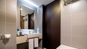 A modern bathroom with a large mirror, a sink, and a bathtub. - THE SKY HOTEL (Cheonan)
