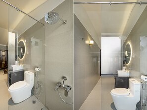 Ein modernes Badezimmer mit einer Glasdusche, einer Toilette und einem Waschbecken.