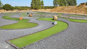 Un jardín ajardinado con senderos sinuosos y áreas verdes.