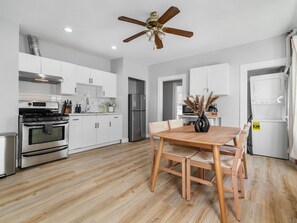 Enjoy cooking in this well-equipped kitchen with a stove, oven, and refrigerator, and dine at the wooden table with two chairs.