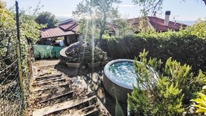 Un jardin avec un jacuzzi, des marches en bois et un espace clôturé.
