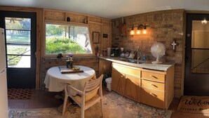 Una cucina rustica con un tavolo di legno, un forno a incasso e un'ampia finestra.
