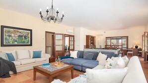 A living room with a sofa, a coffee table, and a chandelier. - Charming finca with large pool and garden in Santanyi for up to 8 persons (Santanyi)