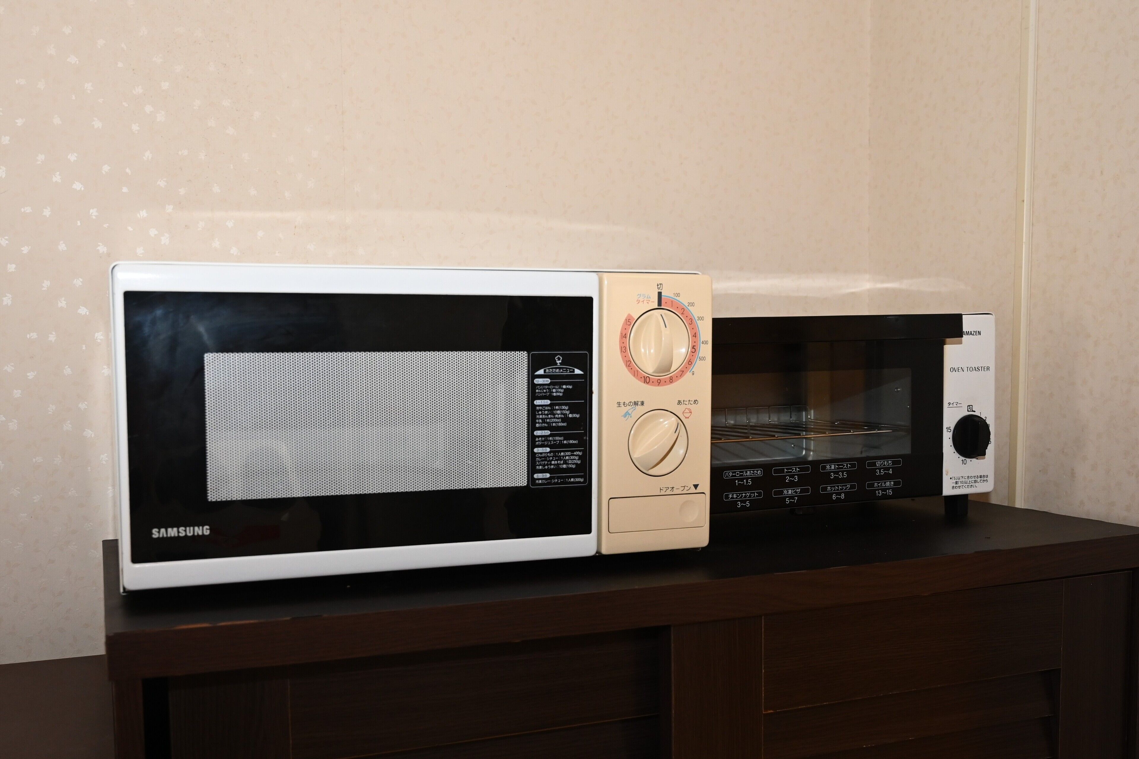 A microwave and oven on a wooden countertop.