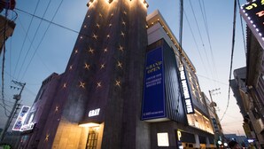 A hotel with a prominent 'GRAND OPEN' sign, a modern facade, and a 'GRAY' sign indicating the hotel name. - Gray Boutique hotel (Tongyeong)